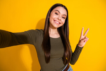 Poster - Photo portrait of lovely teen lady take selfie v-sign dressed stylish khaki garment isolated on yellow color background