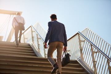 Business, men and walking on stairs outdoor for commute to work with bag, back and low angle in morning. People, travel and rear view outside on steps in city for transportation, job and location