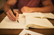© Stratford/peopleimages.com - Man, student and notes with hand in cafe, notebook and university homework for ideas or assignment brainstorming. Education, knowledge and academic planning for exam, studying and writing with pen