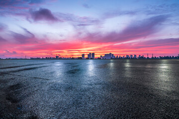 Poster - Asphalt road square and skyline with beautiful sky clouds at sunrise. car background.