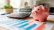 © SebuahKisah - Pink piggy bank on a desk with calculator and financial charts, symbolizing savings, budget, and financial planning