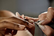 © Seventyfour - Close up shot on nail techs hands using drill machine for natural manicure on clients nails in beauty salon