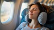 © liliyabatyrova - A young woman wearing a travel neck pillow rests peacefully with her eyes closed on an airplane
