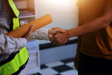 Wall Mural - Architect men making handshake in construction site. Employee or worker shake hands to employer man for greeting, dealing, teamwork, collaboration some project or business. They are good team