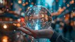 © Dinara - A hand holding a crystal ball with a glowing city inside. The background is a blurred city street with bokeh lights.