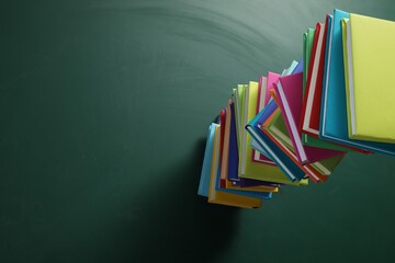Wall Mural - Stack of many colorful books on green background, above view. Space for text