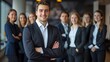 © Irina Ukrainets - Confident business professional standing in front of his team in a modern office setting. Business attire and professional demeanor.