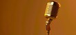 © VISUAL BACKGROUND - A golden microphone on a yellow background.