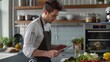 © farhan - young professional using a tablet to follow a recipe while cooking in a modern kitchen