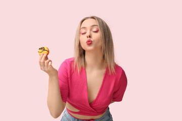 Sticker - Beautiful young woman with orange sweet macaroon on pink background