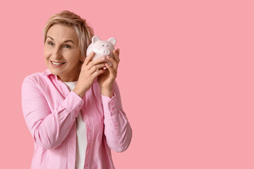 Poster - Happy mature woman with piggy bank on pink background