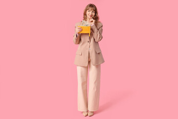 Sticker - Beautiful young woman holding yellow wallet with money on pink background