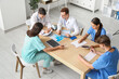 © Pixel-Shot - Group of young doctors working at table in clinic