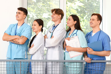 Poster - Group of young doctors on stairs in clinic