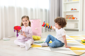 Sticker - Cute little children playing with funny sock puppets in kindergarten