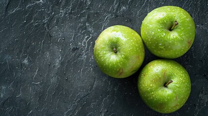 macro top view of two ripe green apples on a slate surface