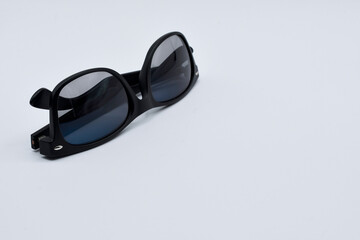 A suitable title in English for this photograph could be:

Folded black sunglasses with reflective lenses on a white background