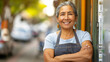© Carmen - Portrait of mature Hispanic businesswoman, standing outside of her shop, small business owner concept, copy space