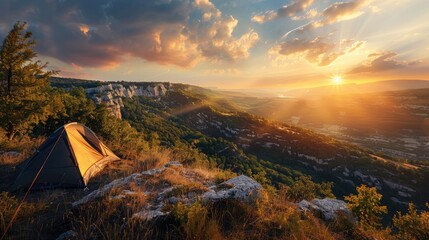 Wall Mural - A scenic campsite on a hilltop overlooking a sprawling valley bathed in the golden light of the setting sun.