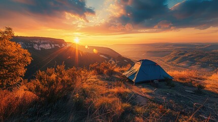 Wall Mural - A scenic campsite on a hilltop overlooking a sprawling valley bathed in the golden light of the setting sun.