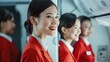 © A Denny Syahputra - Flight attendants in red uniforms smile in an airplane cabin