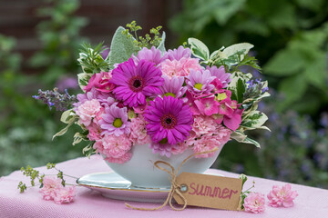 Wall Mural - Blumen-Arrangement mit pink Gerbera, Chrysanthemen, Rosen und Hortensienblüten im vintage Sauciere im Sommergarten