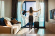 © shine - Attractive businesswoman with suitcase opening curtains, looking at the view from window of Beautiful panoramic tropical seascape horizon. Peace sunset sky, relax. Positive energy, meditation, island.