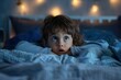 © ylivdesign - Young child lying awake in bed at night looking scared with bedroom lights in the background