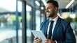 © Achmad Khoeron - happy young latin business man executive holding tablet at the office