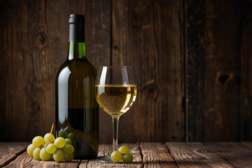 Glass of white wine on old wooden table.