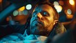 © liliyabatyrova - A close-up portrait of a man sleeping in a car, bathed in the warm glow of city lights