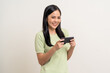 © Chanakon - Excited Beautiful young asian women play mobile game and standing on isolated white background. Happy smiling female Playing game on smartphone winning victory moment. Very enjoy and fun relax time