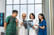 © Chanakon - Medical team doctor planning research in a hospital and talking about patient symptoms as results x ray film. Discussion healthcare meeting group speaking about medicine strategy various action