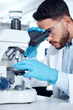 © peopleimages.com - Man, microscope and research analysis in lab, biochemist and innovation healthcare study with virus sample. Investigation, cure development and breakthrough, medical and goggles with professional