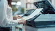 © PNG - Businessman print paper on a multifunction laser printer in business office.