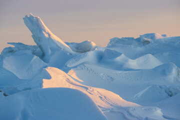 Wall Mural - Winter arctic landscape. View of snow and ice at sunset. Ice hummocks on the frozen sea in the Arctic. Cold frosty winter weather. Harsh polar climate. Travel and hikes to the far north to the Arctic.