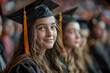 © Evhen Pylypchuk - A girl in a graduation cap sits in the audience while others receive diplomas on stage to applause.