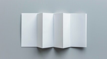 A blank folded piece of paper with multiple creases, placed on a plain gray surface, displaying a neutral, minimalist design perfect for various graphical purposes.