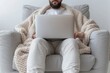© AnuStudio - A man is sitting in a chair with a laptop on his lap