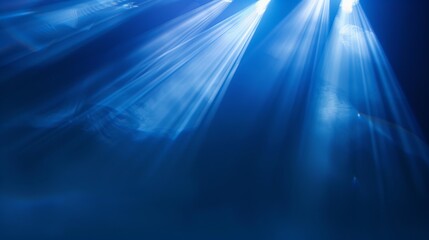 Wall Mural - beams of spotlight on royal blue background creating abstract light effects ideal for stage performa