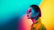 © NaphakStudio - A woman in sunglasses and a yellow coat, bathed in colorful neon lights, exuding a confident and stylish aura.