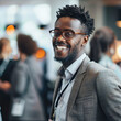 © M - Smiling businessman with glasses and beard attending a networking event