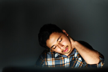 Poster - Night, tired and business man with neck pain with stress, burnout or overwork at creative startup. Fatigue, injury and worker with joint problem, sore muscle or massage on deadline on wall background