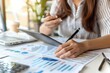 © siripimon2525 - European-American finance officer managing budgets, detailed and analytical, spreadsheets and reports