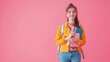 © Sofiia Bakh - a student scientist with a backpack and a textbook on a pink background