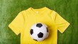 © Alexandre - uma camiseta amarela e uma bola de futebol em cima de um gramado de futebol