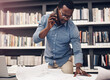 © peopleimages.com - Architecture, blueprint and black man with phone call in office for project, development or review. Contractor, paper and person with technology at work for floor plan, discussion or update to client