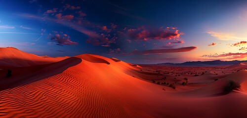A breathtaking desert landscape with red and orange sand dunes under a twilight sky