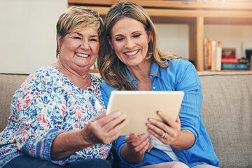 Wall Mural - Senior mother, daughter and happy with tablet on sofa in home for digital photo album and memories. Family parent and women with smile for ebook or streaming comedy for entertainment, fun and bonding