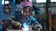 © Michal - A hard-working woman in a workshop, a black woman, a welder